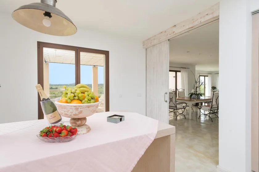 Comedor con un frutero sobre una mesa junto a una puerta abierta.