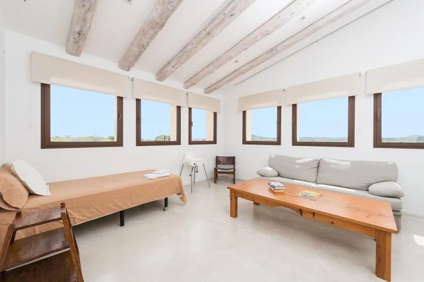 Una sala de estar luminosa con asientos y varias ventanas.