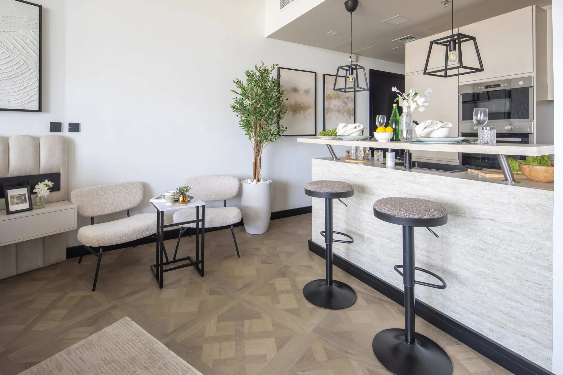 A bright open-plan living and kitchen area features seating beside a breakfast bar.