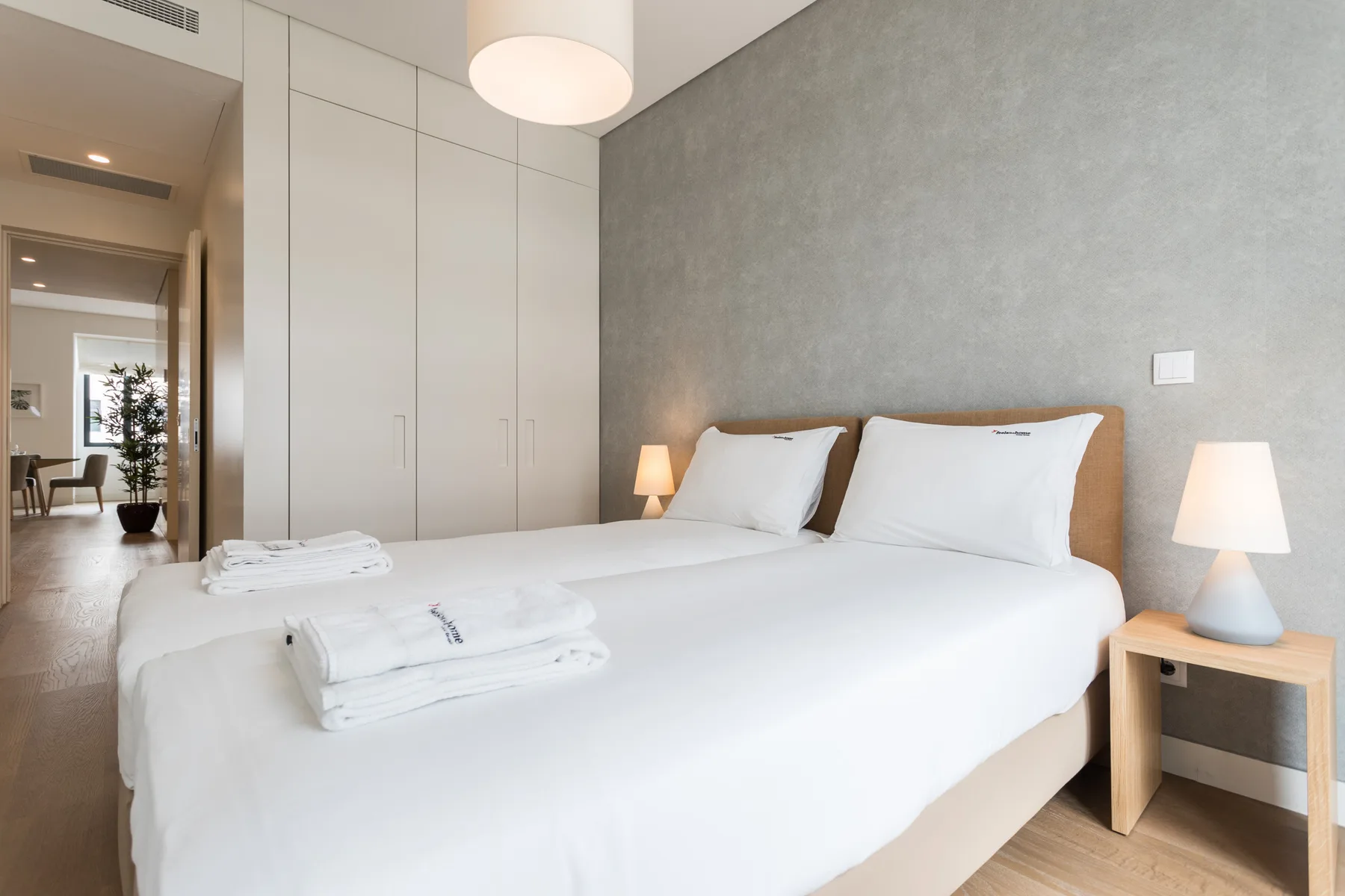 Dormitorio con una cama bien tendida y lámparas de noche.