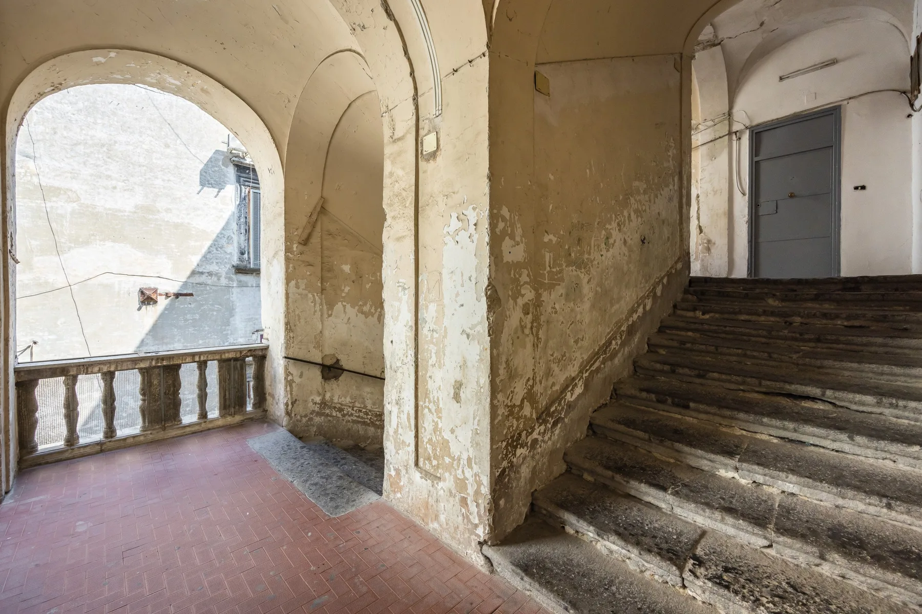 Una escalera antigua con peldaños de piedra desgastados y una abertura arqueada.
