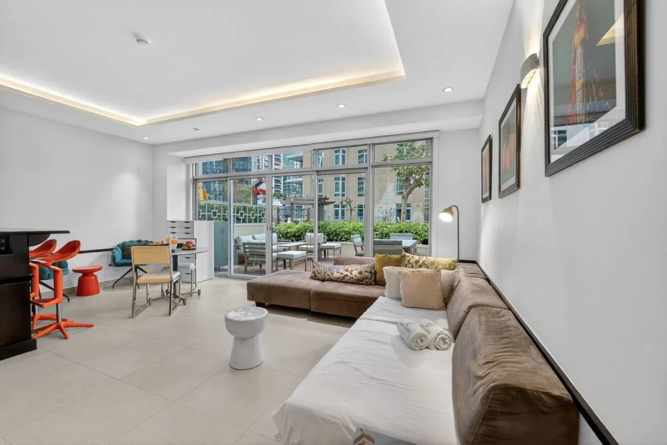 Una sala luminosa con asientos, una mesa pequeña y ventanas amplias.