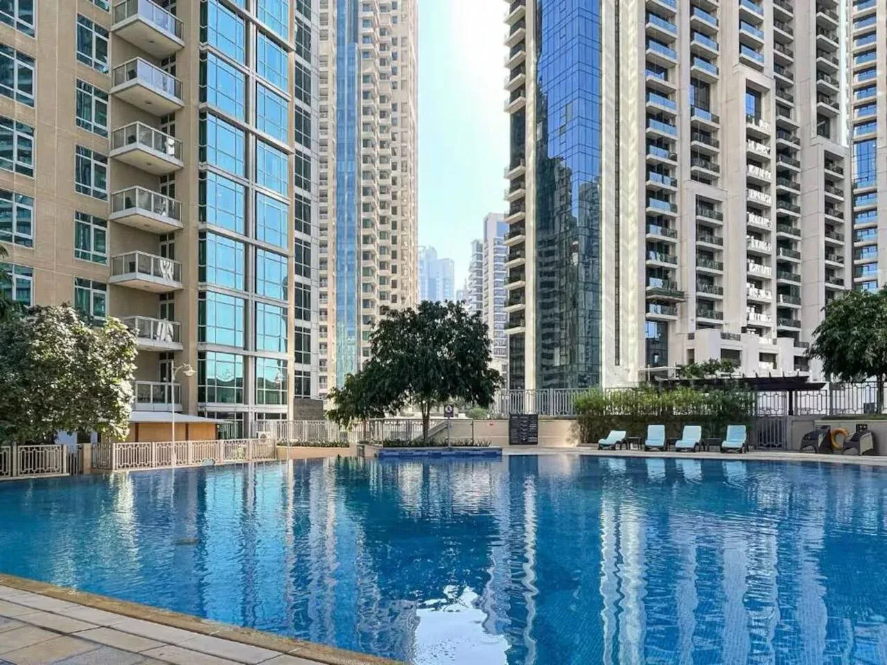 Una piscina al aire libre está rodeada de edificios residenciales altos.