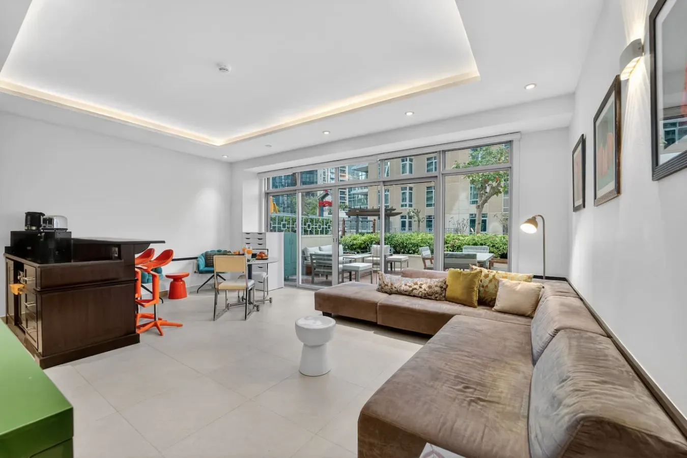 Una sala luminosa con una zona de asientos y grandes ventanas.