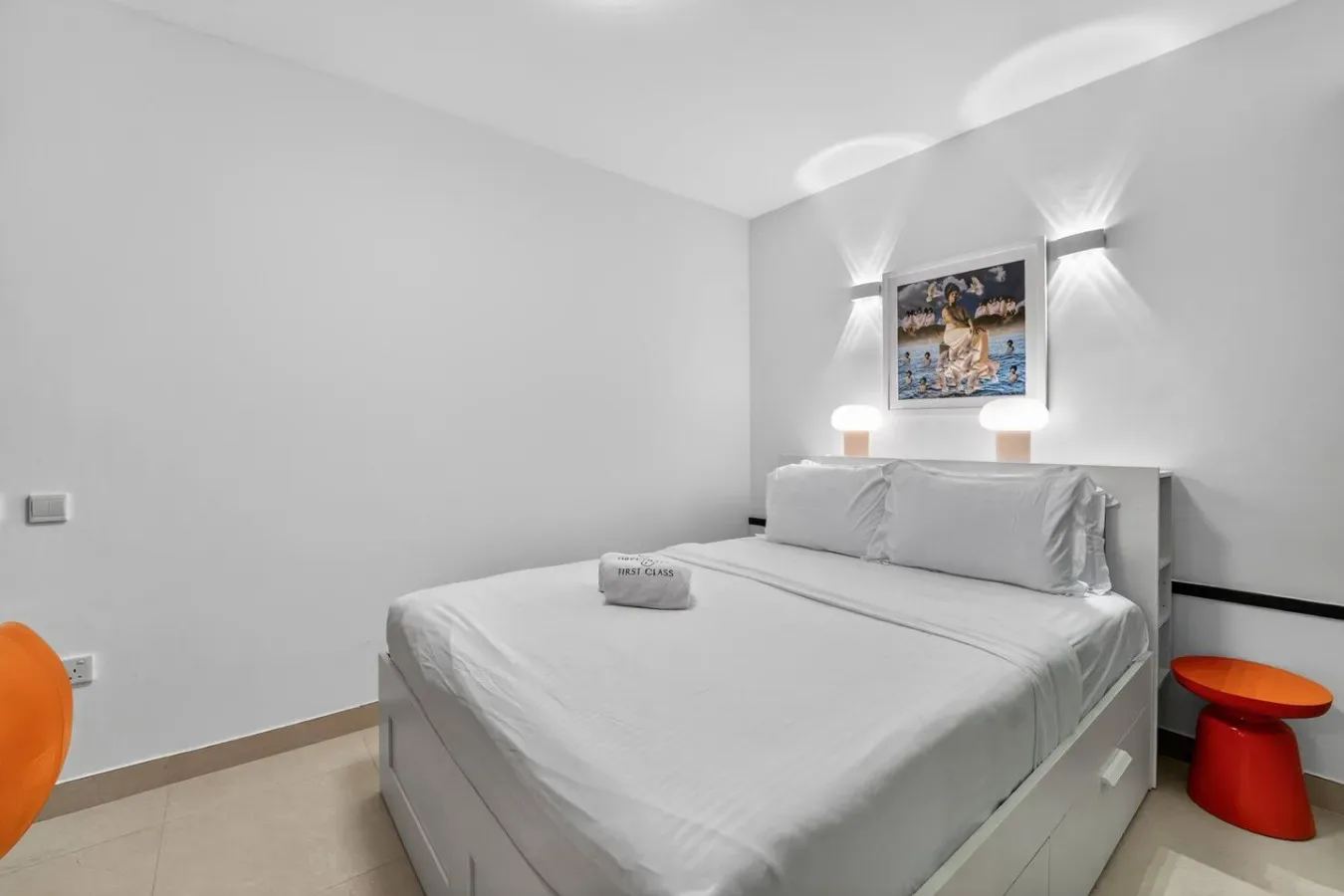 Un dormitorio con una cama bien tendida y pequeñas mesas de noche.