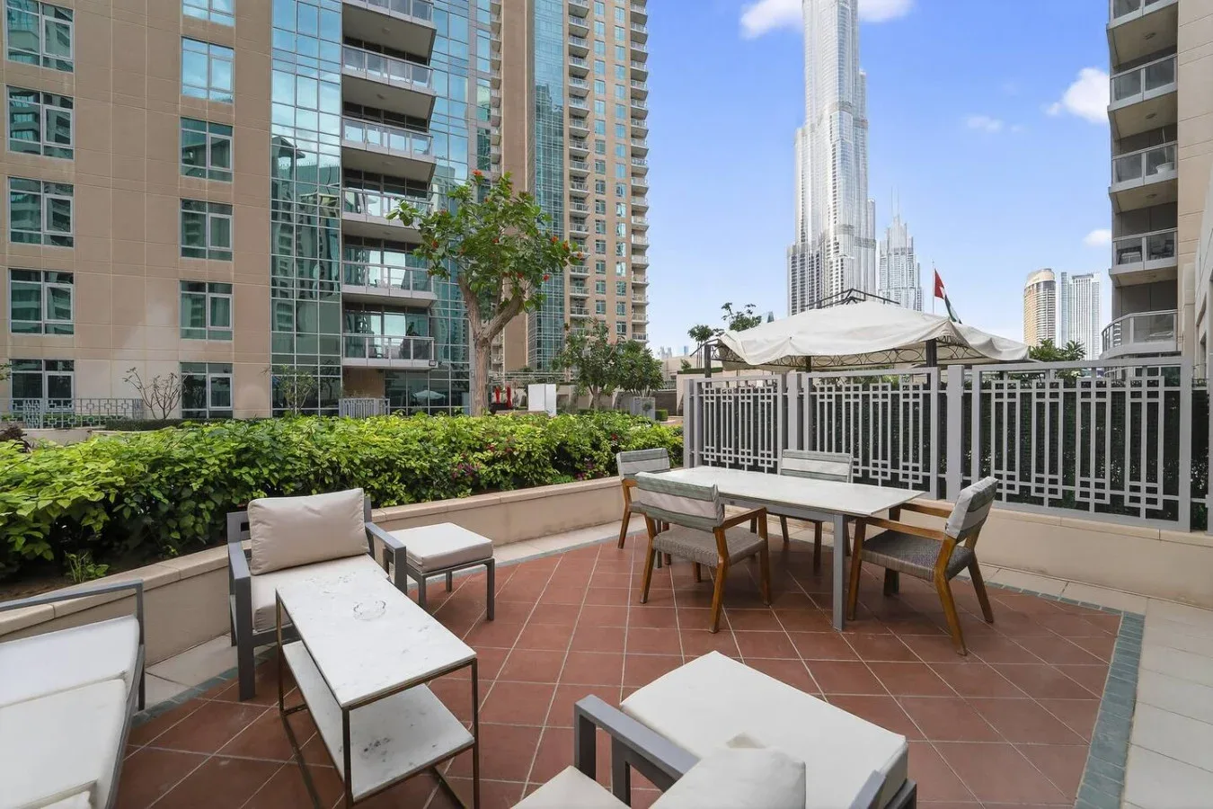 Una terraza en la azotea tiene asientos al aire libre y una mesa bajo un toldo.