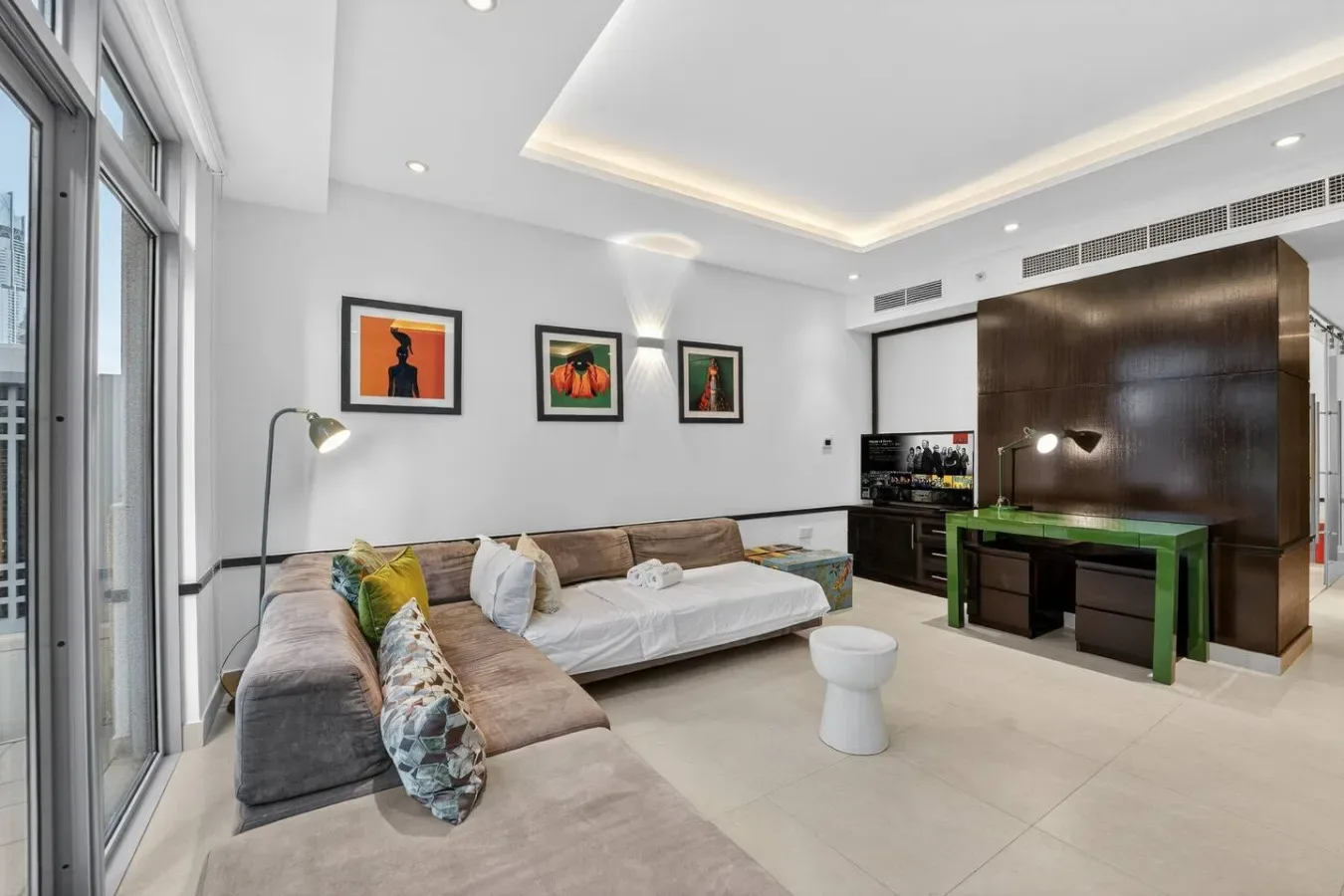 Una sala de estar luminosa con asientos en forma de L y cuadros enmarcados.