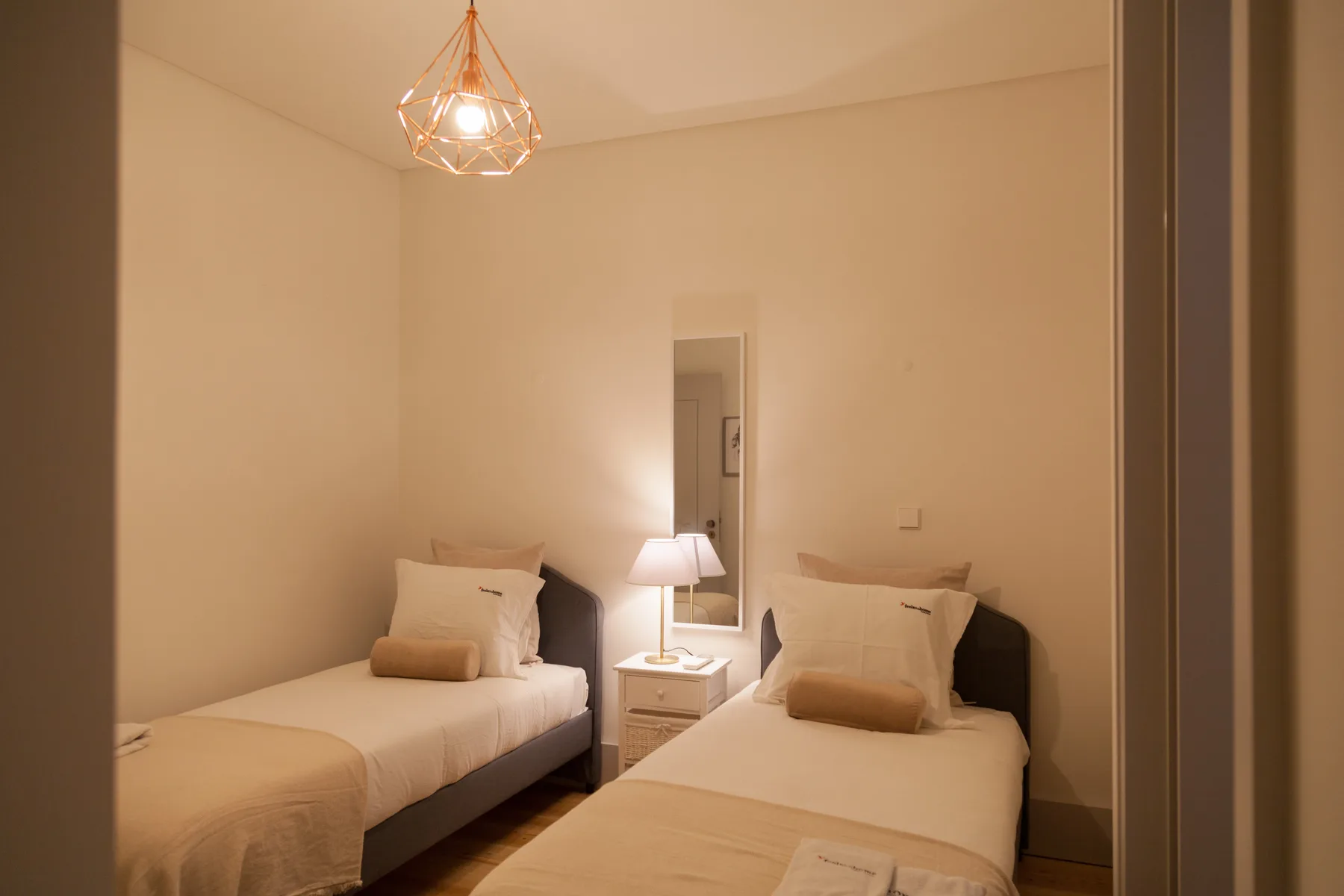 A bedroom with two single beds and a bedside table between them.