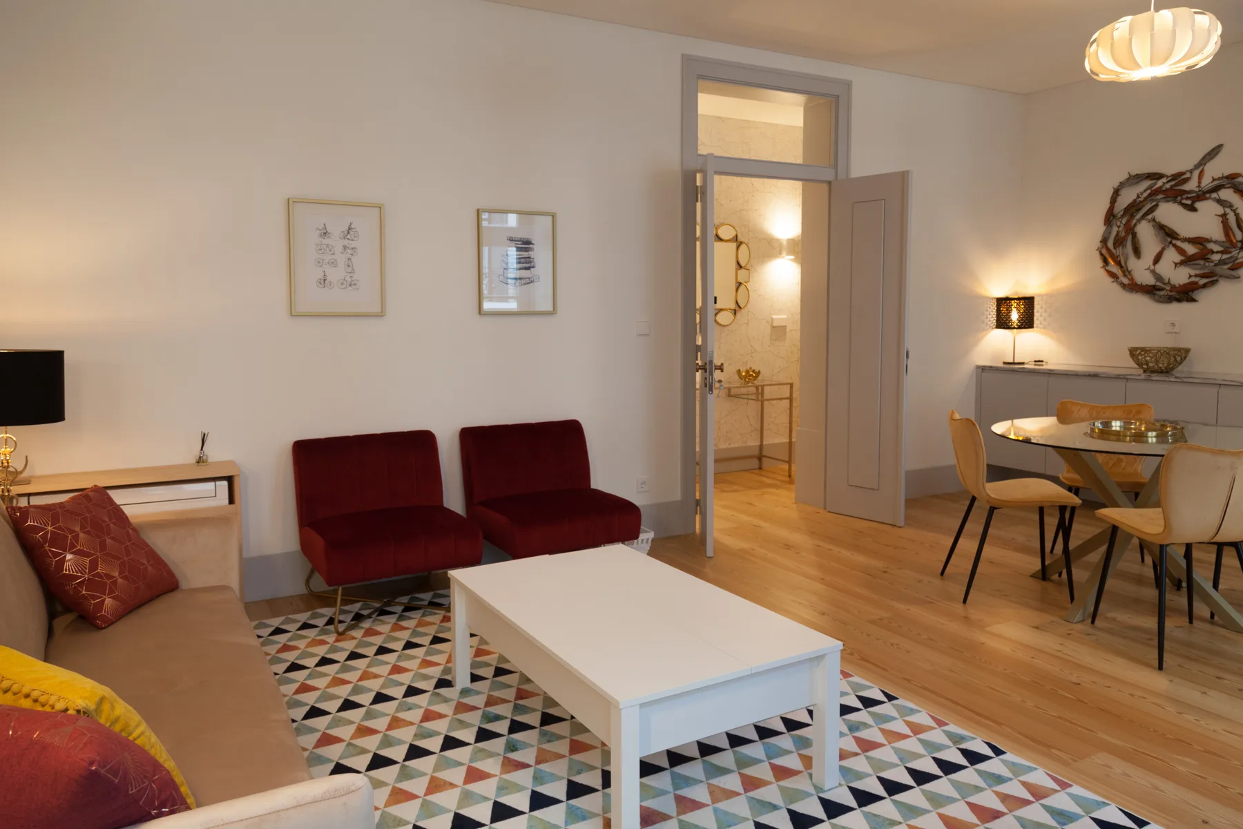 A living and dining area with seating, a coffee table, and an open doorway.