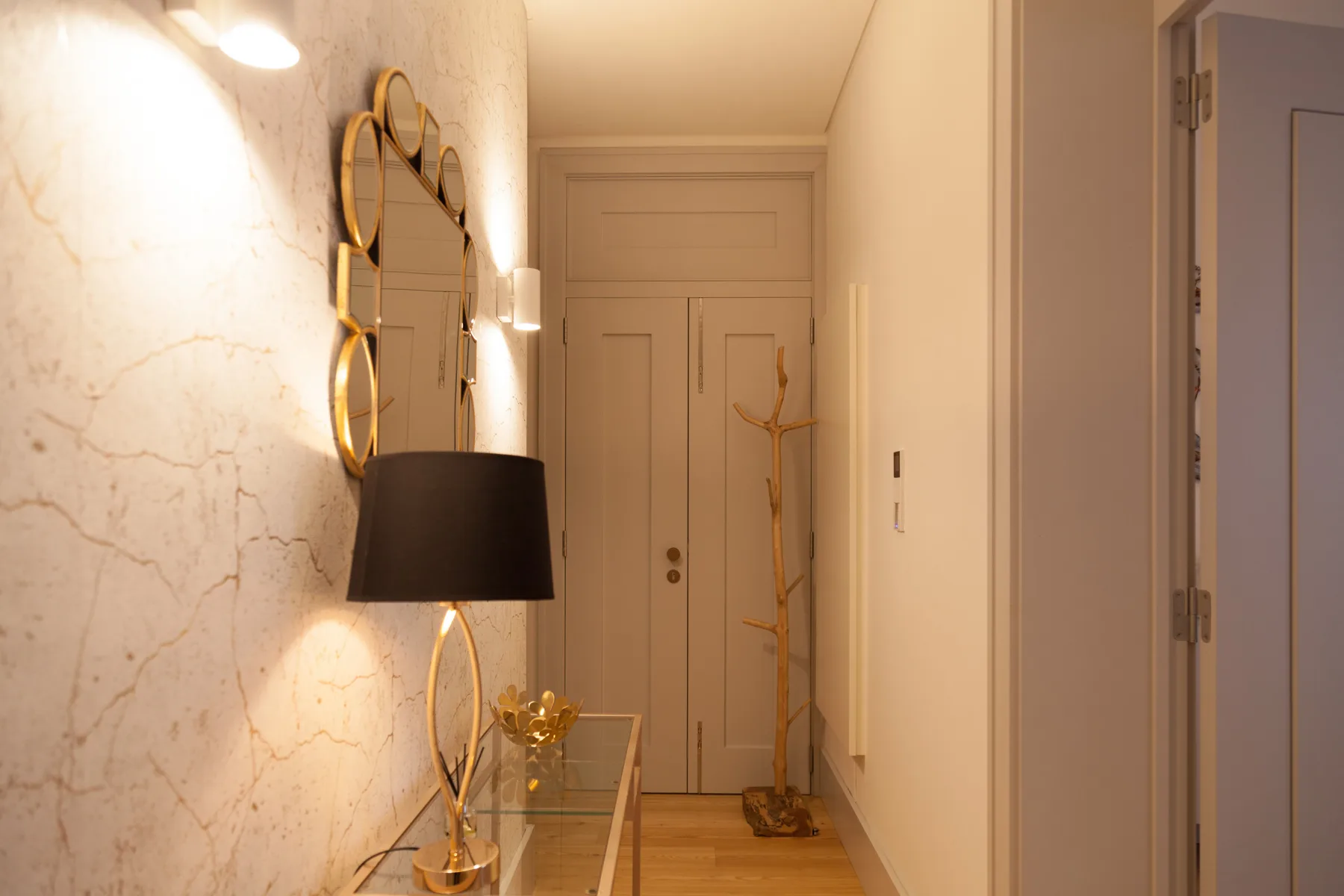 A warm-toned entry hall with a console table and a coat stand by the door.