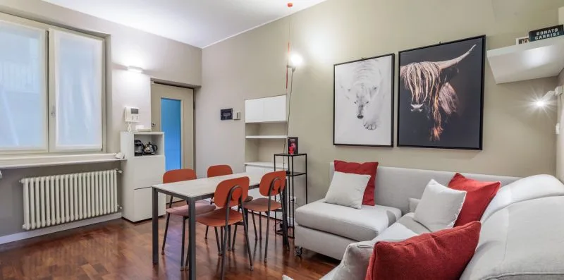 Una sala de estar con mesa de comedor y asientos bajo cuadros de animales.
