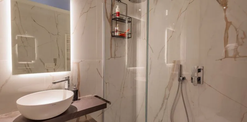 Un baño moderno con lavabo, espejo y ducha de vidrio.
