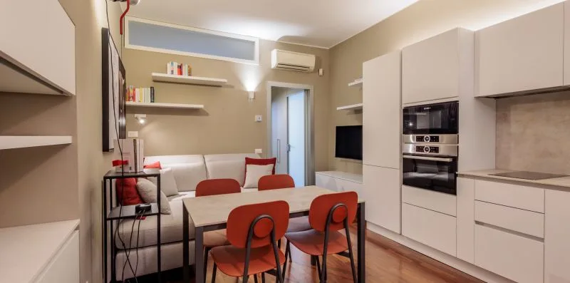 A compact kitchen and dining area with a table beside a built-in oven.