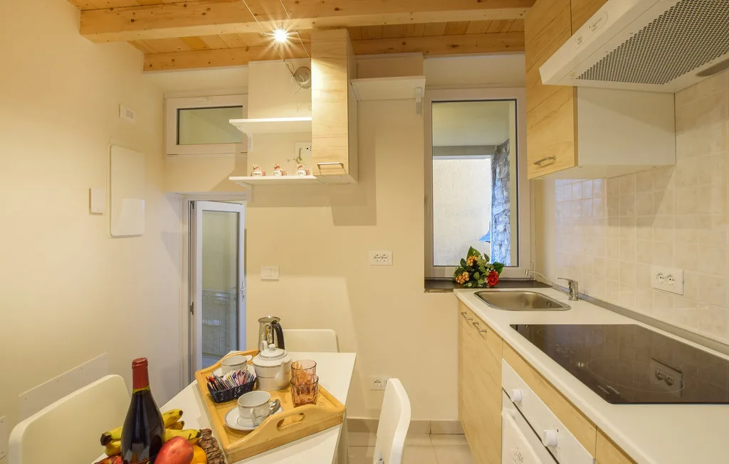 A compact kitchen with a countertop, sink, and dining table.