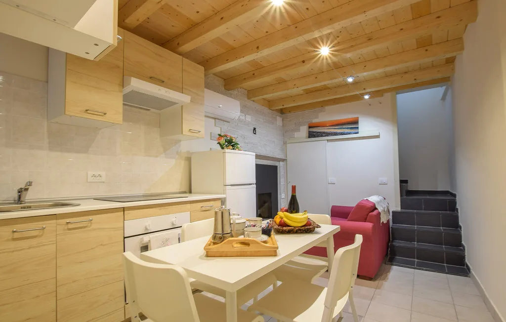 Una cocina y comedor compactos con armarios de madera y una mesa.