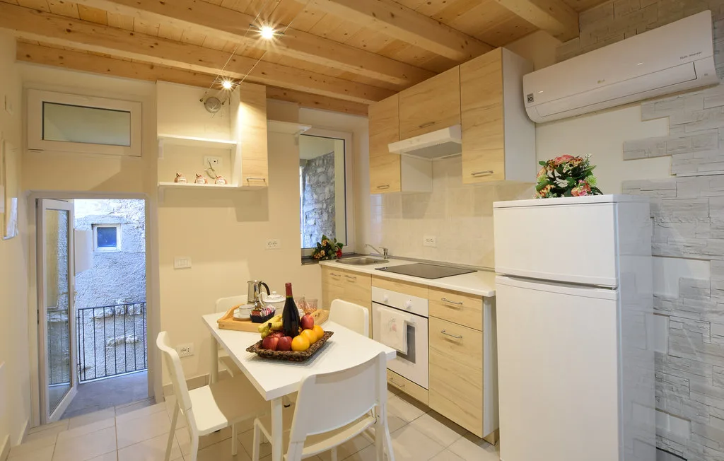 A compact kitchen and dining area with light wood cabinets and a table.