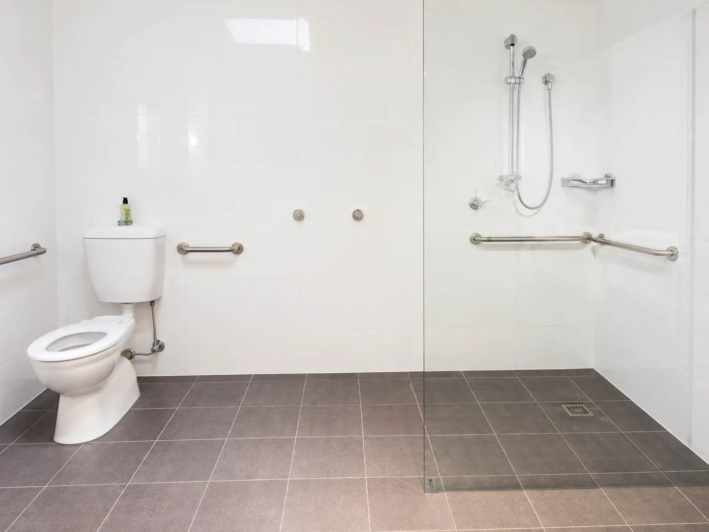 Un baño luminoso con un inodoro y una ducha.