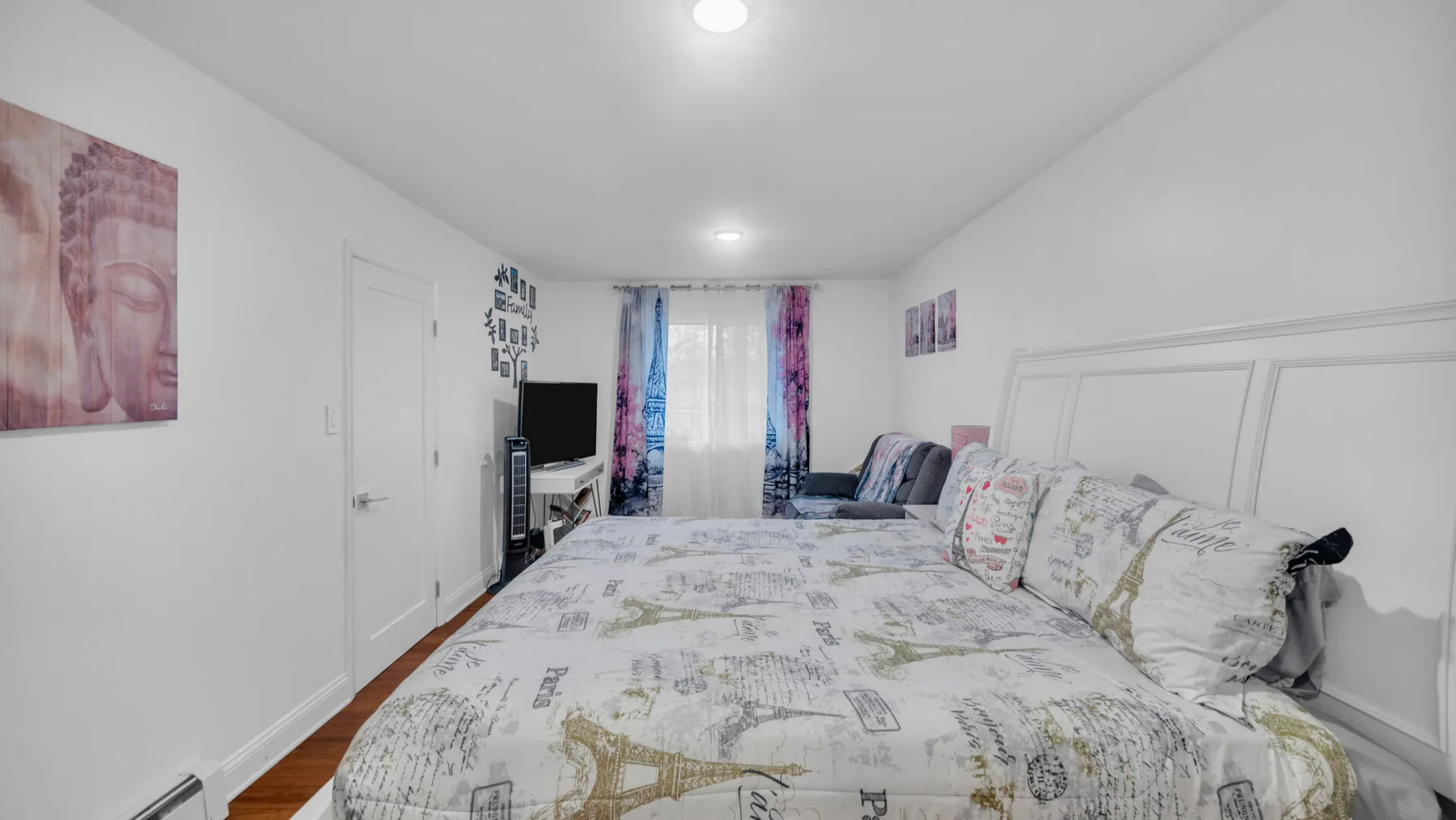 Un dormitorio con una cama grande, cortinas coloridas y un televisor.