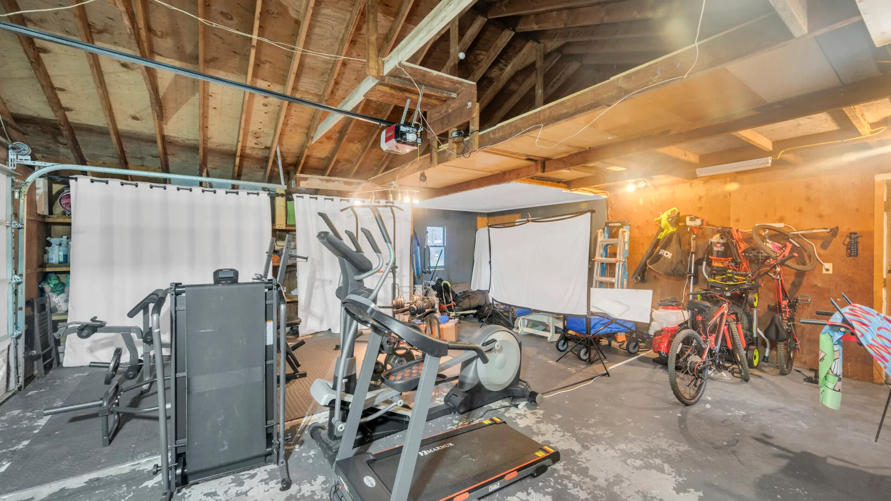 Una zona de ejercicio en el sótano con equipos de entrenamiento y bicicletas.