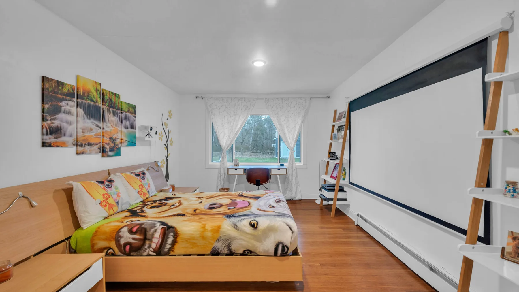 Un dormitorio con una cama, cuadros en la pared y una pantalla de proyección grande.