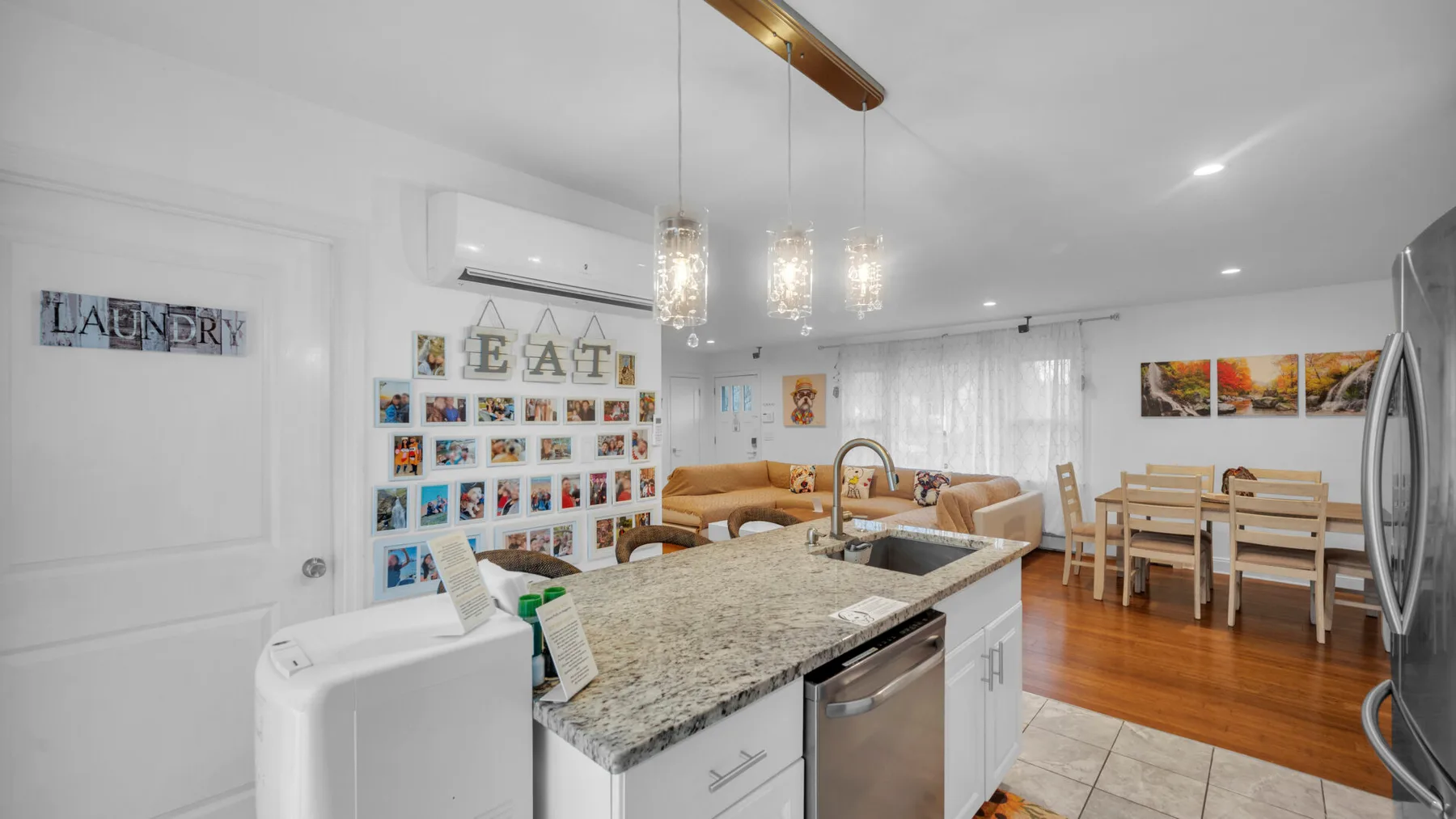 Una luminosa cocina con comedor cuenta con una isla central y una mesa de madera.