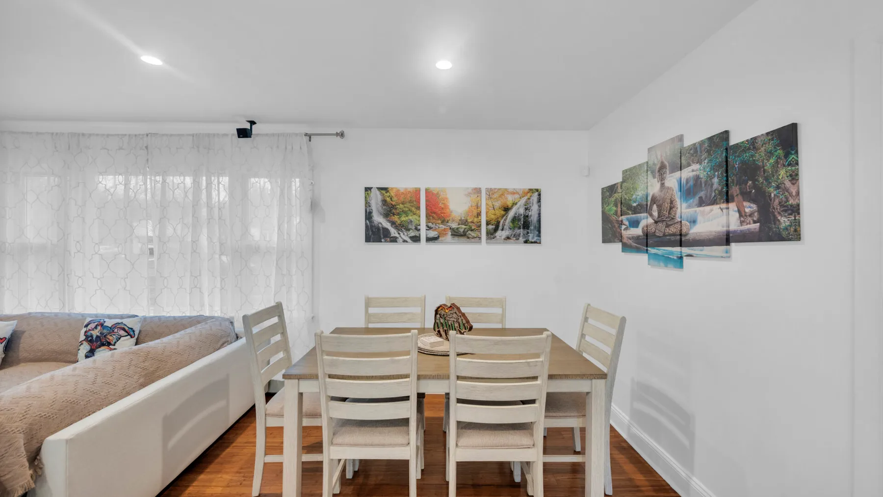 Un comedor con una mesa de madera y sillas junto a una zona de estar.