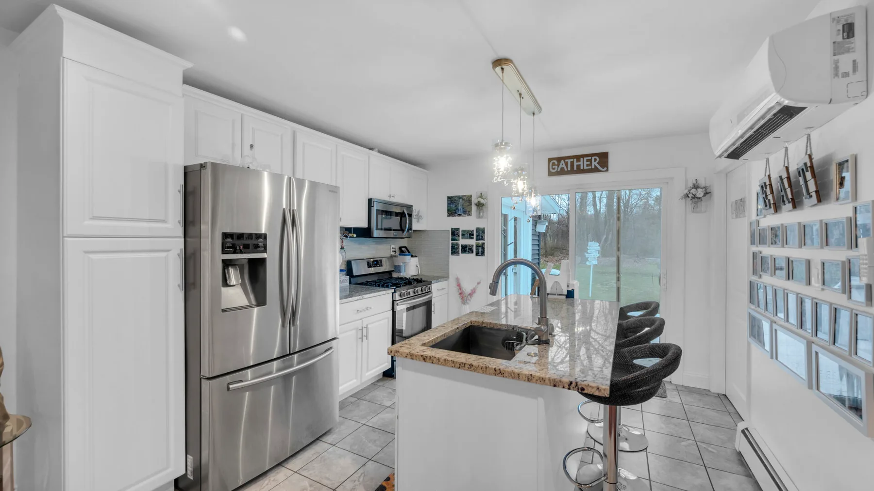 Una cocina luminosa con una isla central y electrodomésticos de acero inoxidable.