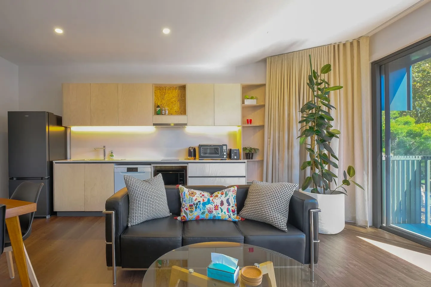 An open-plan living room and kitchen with a sofa facing the kitchen.