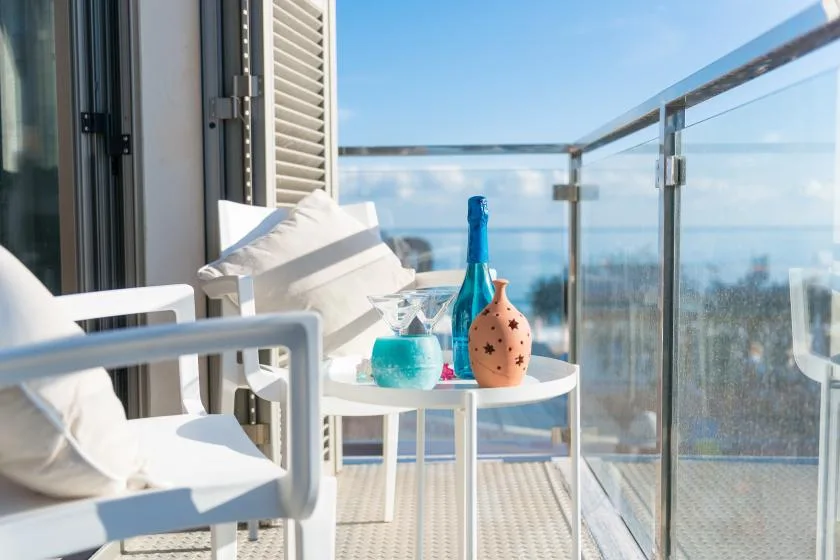 A balcony seating area with glass railings and a small table.