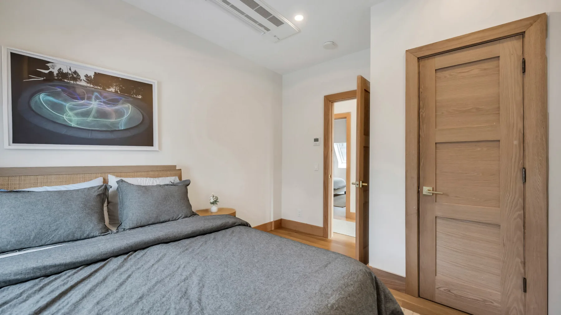 A bedroom with a neatly made bed and wooden doors.