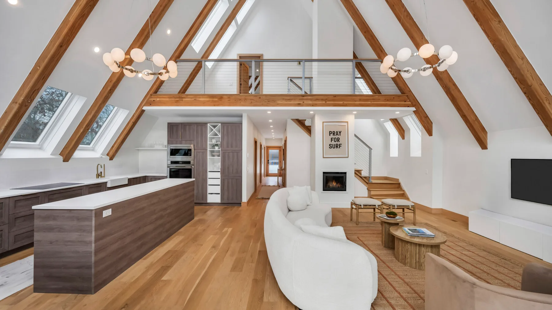 An open-plan loft living area features a kitchen island and curved seating.