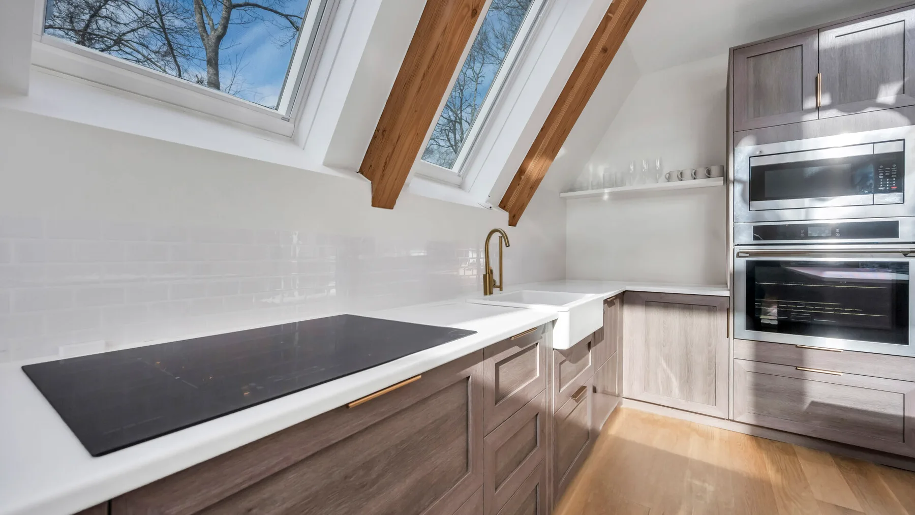 A bright kitchen with a long counter, cooktop, and skylights.