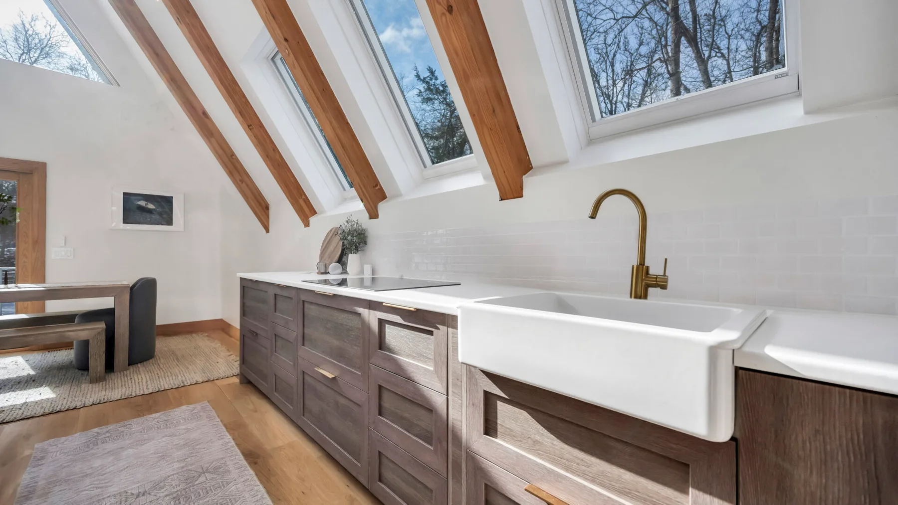 A bright kitchen with a large sink beneath sloped skylights.