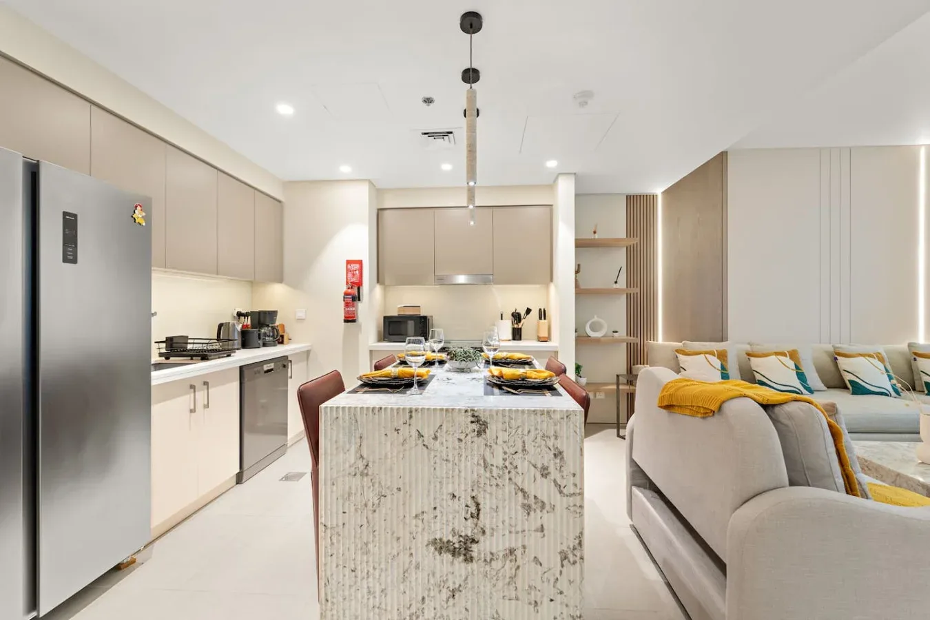 Cocina y sala de estar de concepto abierto con una isla central y asientos.
