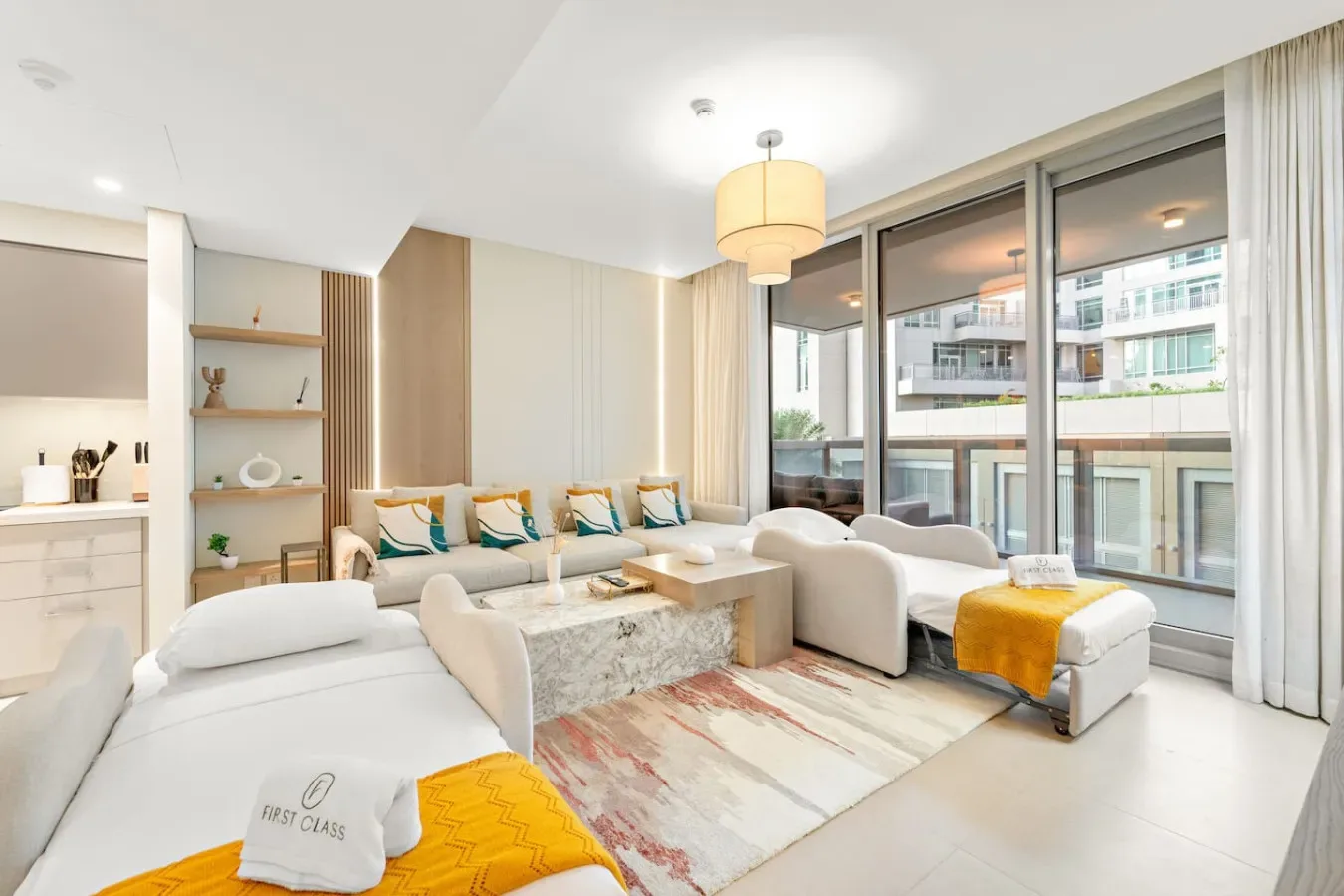 Una sala luminosa con asientos alrededor de una mesa baja junto a grandes ventanales.
