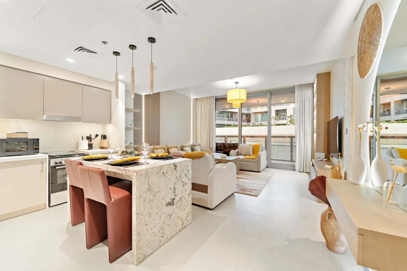 Cocina y sala de estar de concepto abierto, con isla de comedor y grandes ventanas.