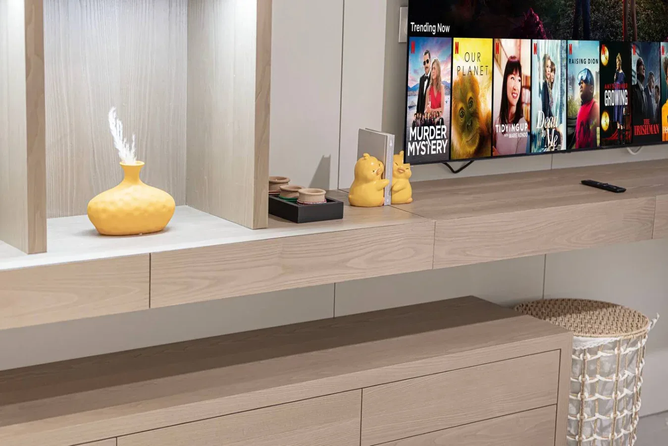 Una consola multimedia de sala muestra un televisor junto a pequeños objetos decorativos.