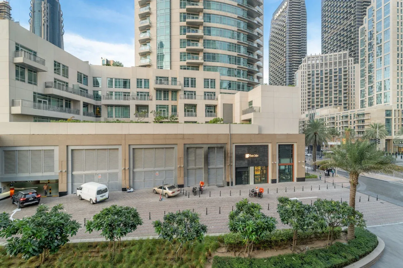 Un moderno complejo urbano con edificios acristalados y locales a nivel de calle.