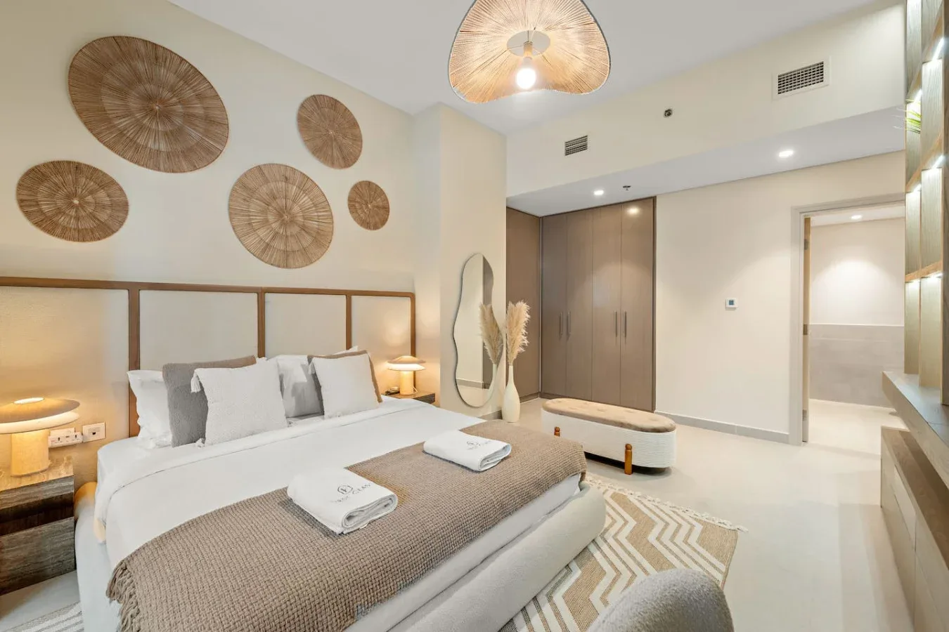Un dormitorio luminoso con una cama grande y adornos tejidos en la pared.