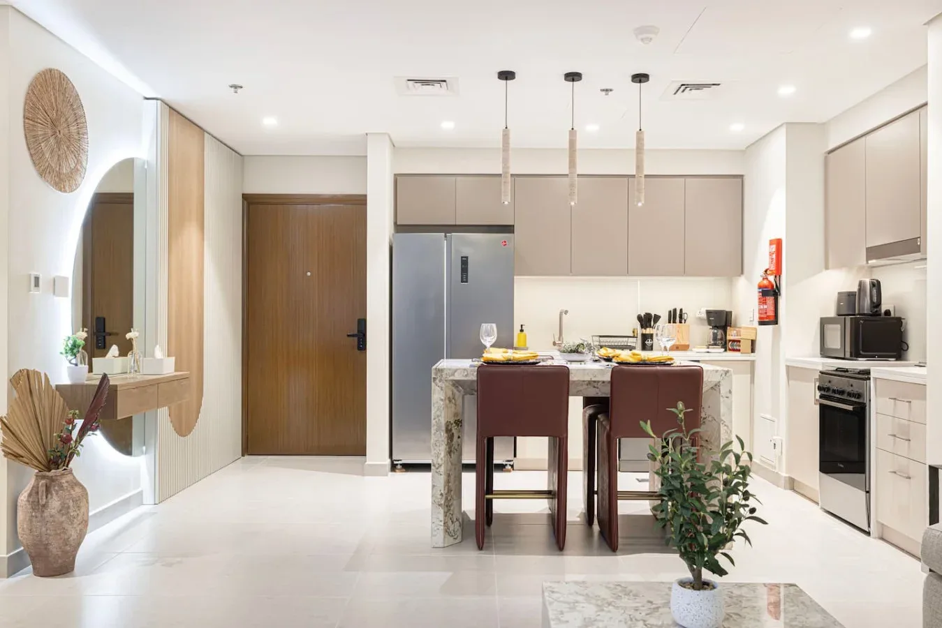 Una cocina y comedor luminosos con una isla central y lámparas colgantes.