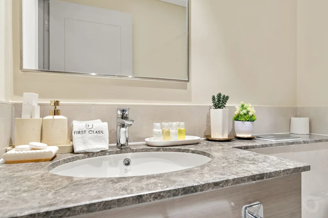 Un tocador de baño con un espejo amplio, lavabo y encimera.