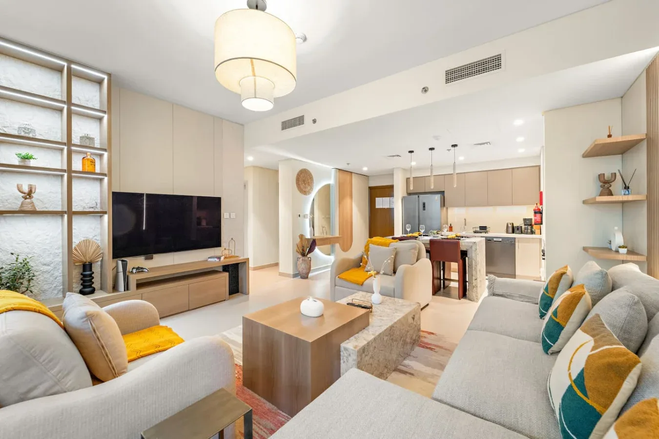 Sala de estar de planta abierta con asientos, una mesa de centro y una cocina al fondo.