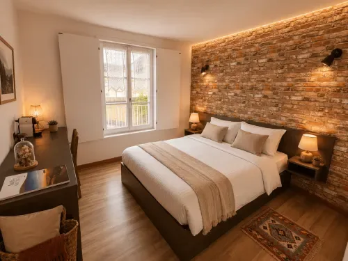 Habitación doble con pared de ladrillo visto, cama tamaño queen y escritorio.