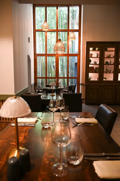 Comedor con mesa de madera y vistas al jardín de bambú.
