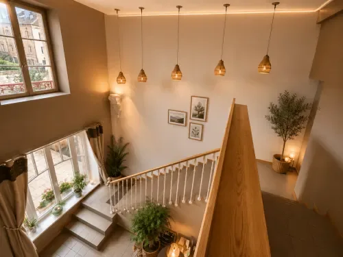 Escalera con barandilla de madera, lámparas colgantes y plantas.