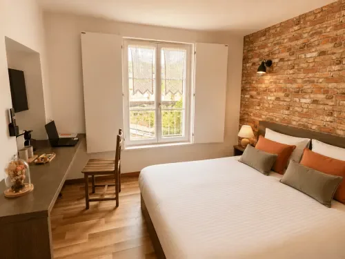 Habitación doble con pared de ladrillo visto, escritorio y vistas al jardín.