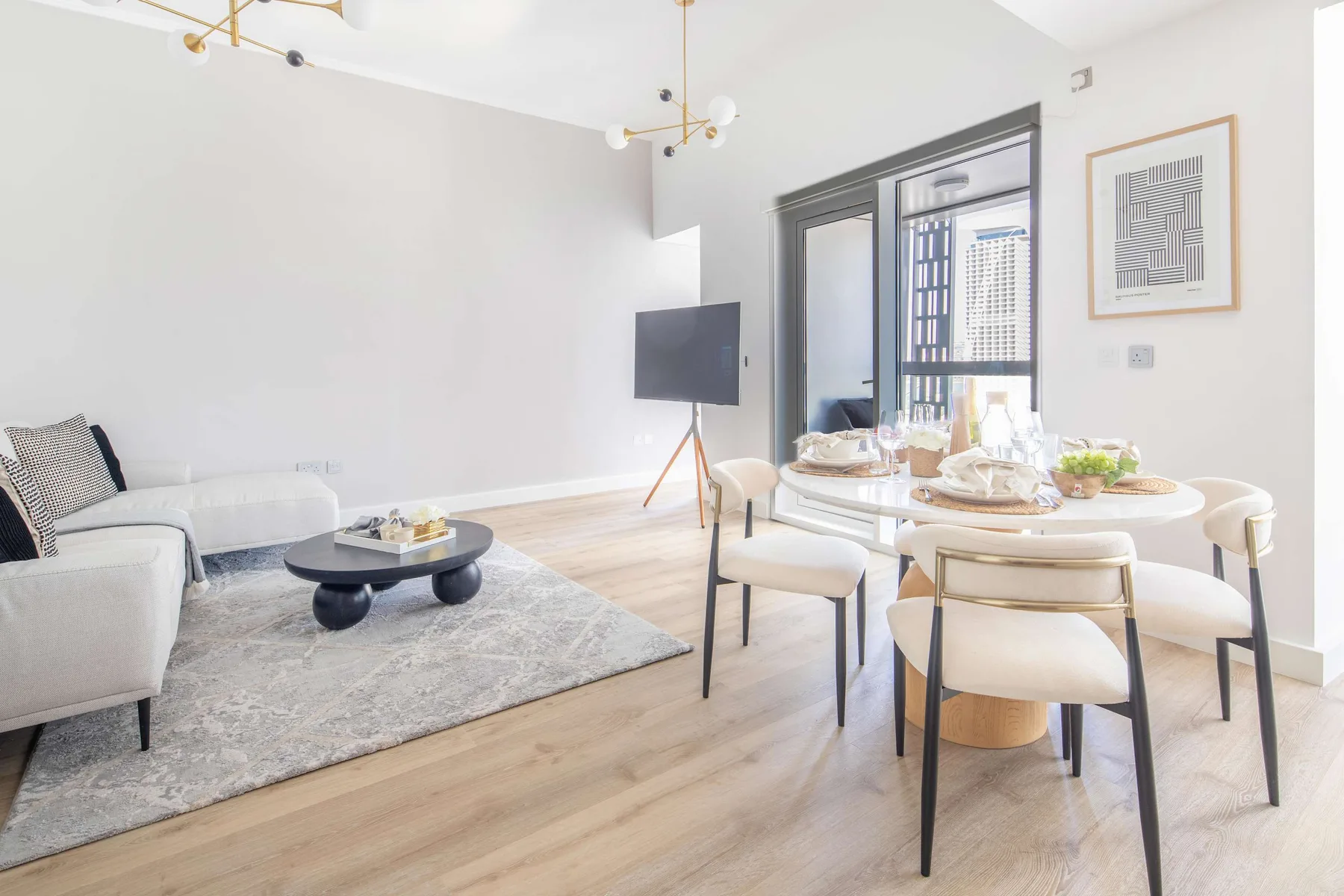 Una luminosa sala de estar y comedor con mesa, asientos y televisor.