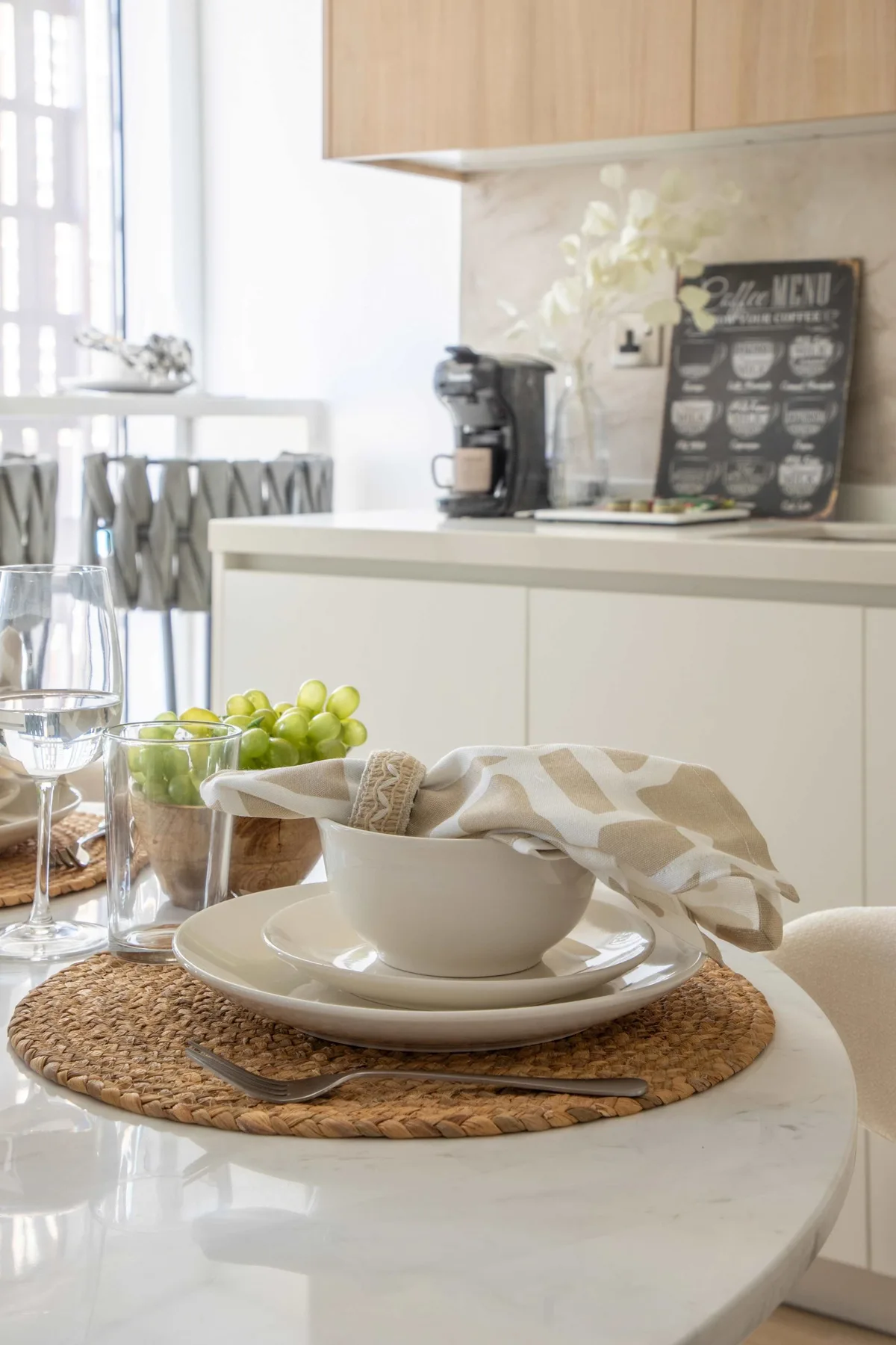Una cocina luminosa con una cafetera y una mesa puesta.