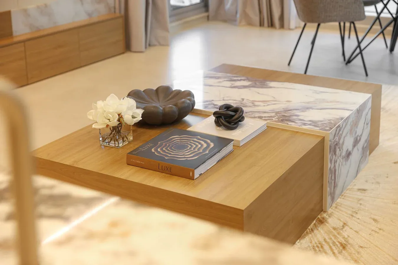 Una zona de estar con una mesa baja de madera y objetos decorativos.