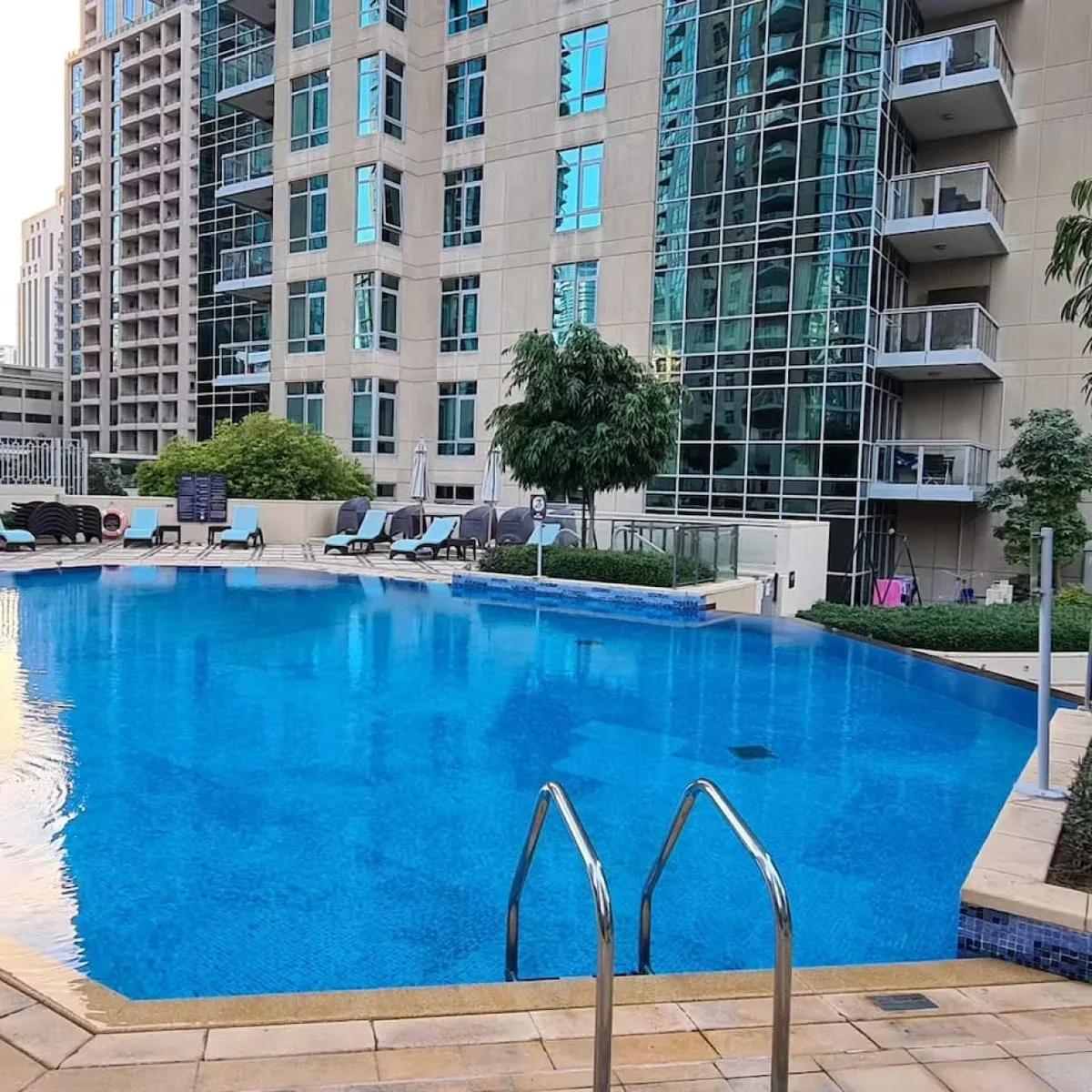 Una piscina está junto a un edificio moderno de gran altura.